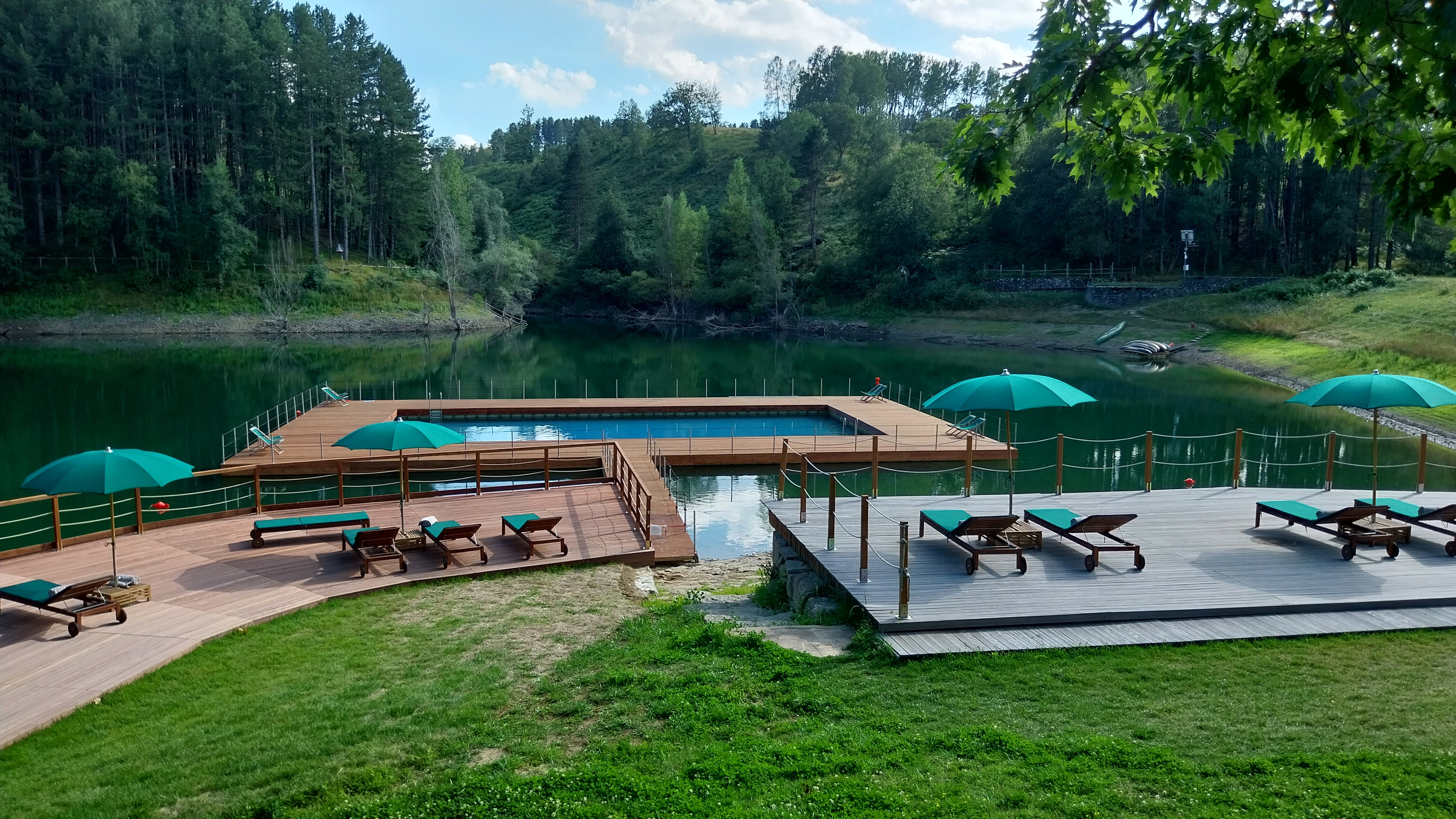 Solarium e piscina galleggiante in contesto naturalistico